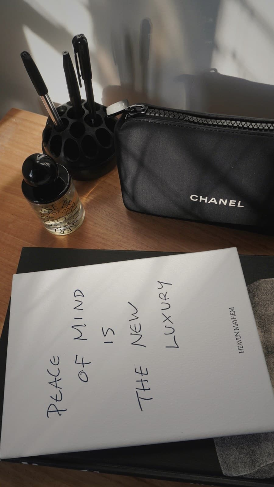 A handwritten note sits on an organized workspace desk, papers and a pen arranged in clean lines.