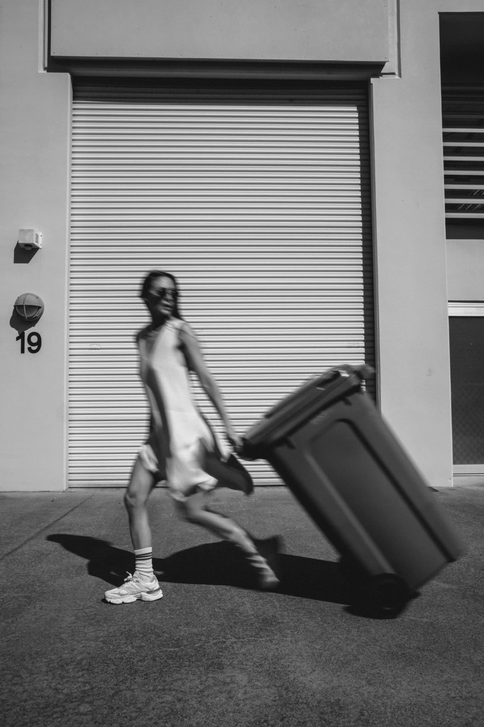 Woman hauling the household workload to the curb