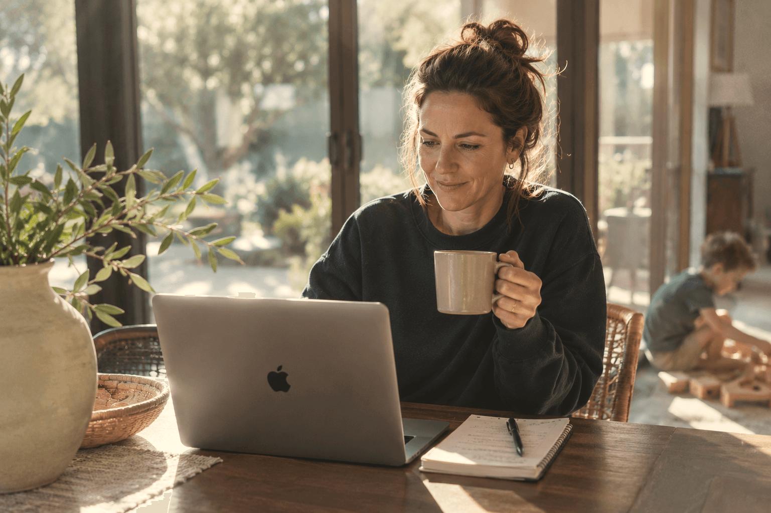 A mother with coffee at her laptop on a Sunday morning. Relaxed, the week already planned